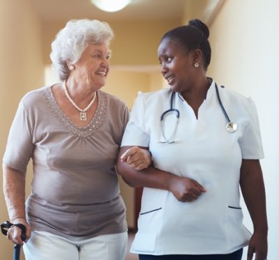 care provider walking with a senior resident 